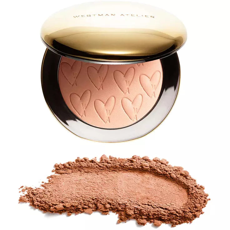 A makeup compact with embossed hearts next to a swatch of the product.