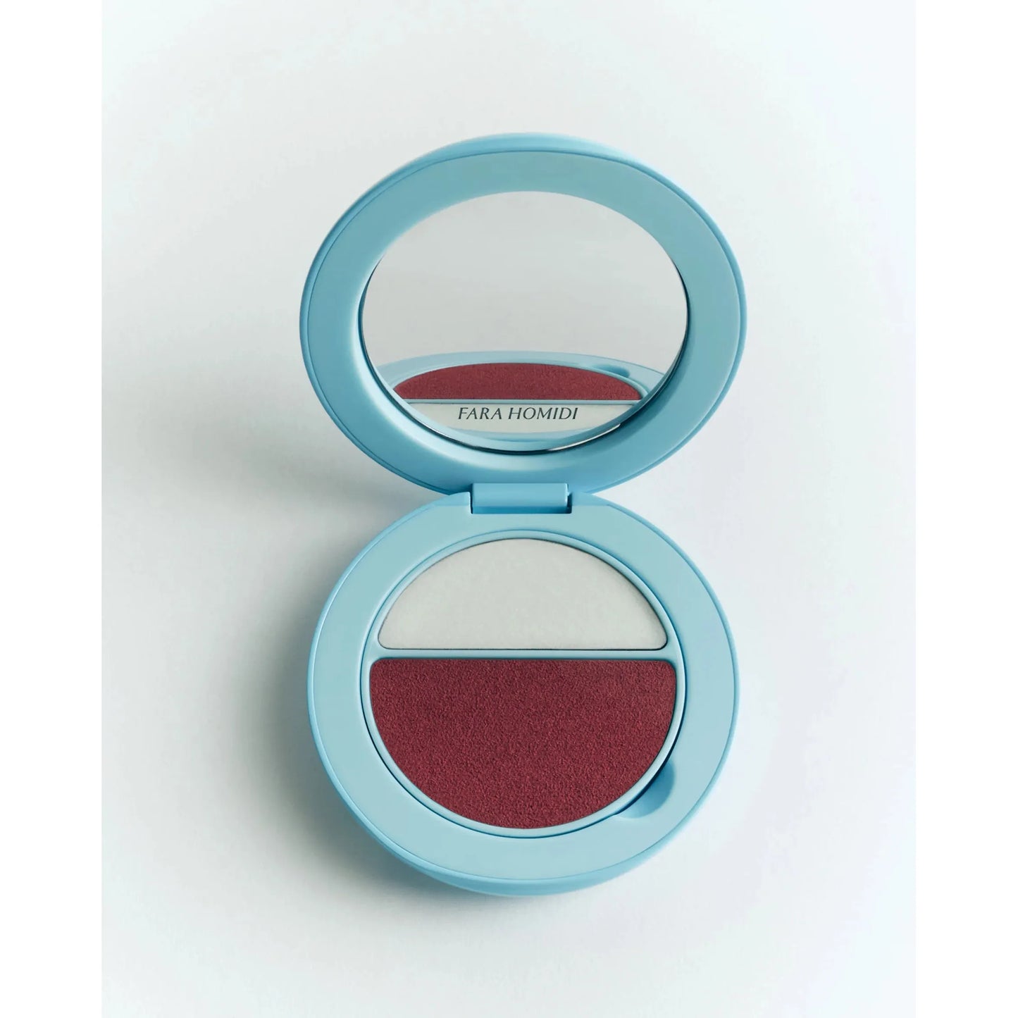 Compact makeup palette with mirror and two shades of cosmetics.