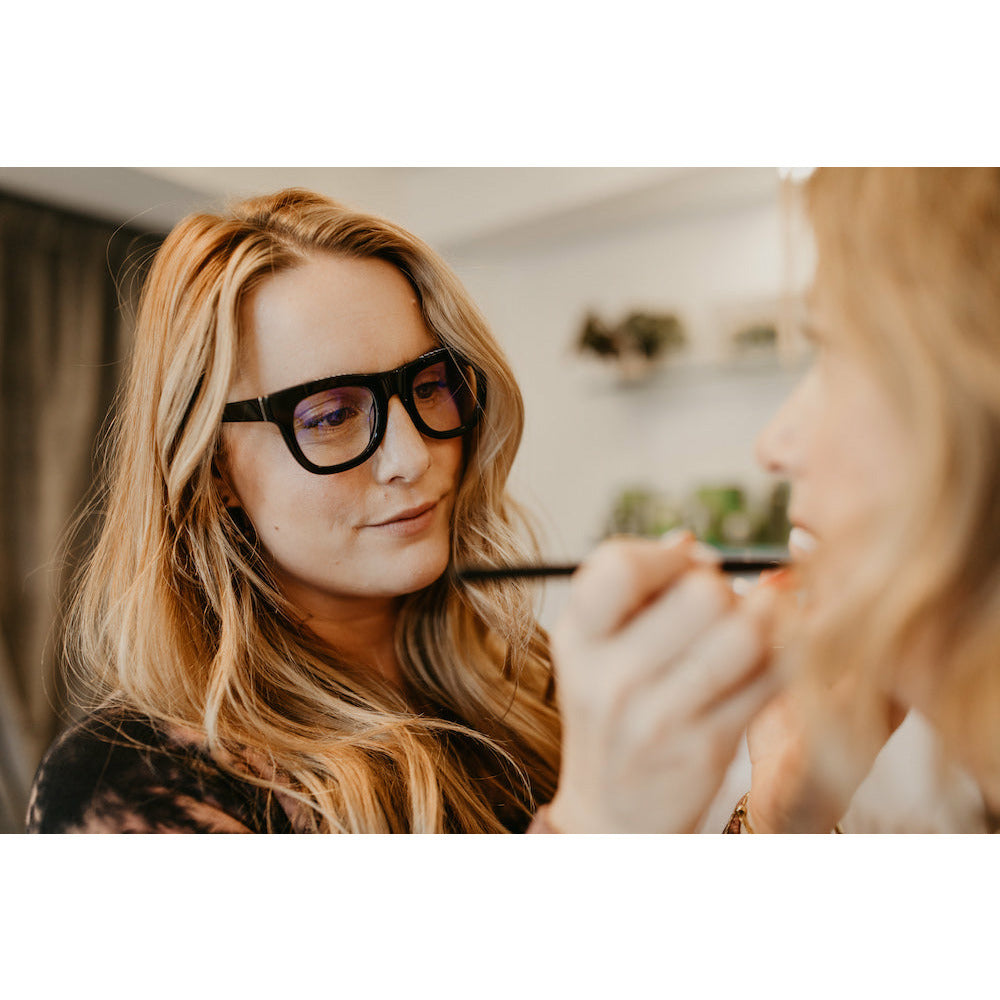 Makeup artist applying cosmetics to a client.