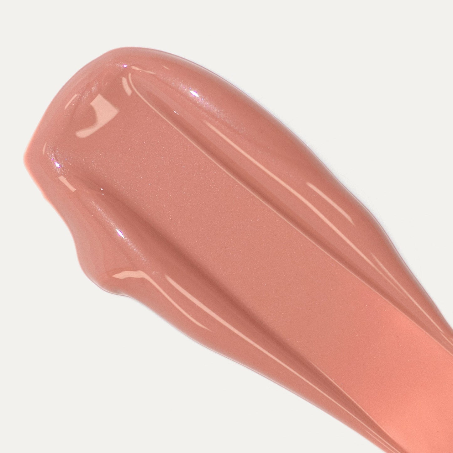 A close-up of a smear of pinkish-beige lip gloss.